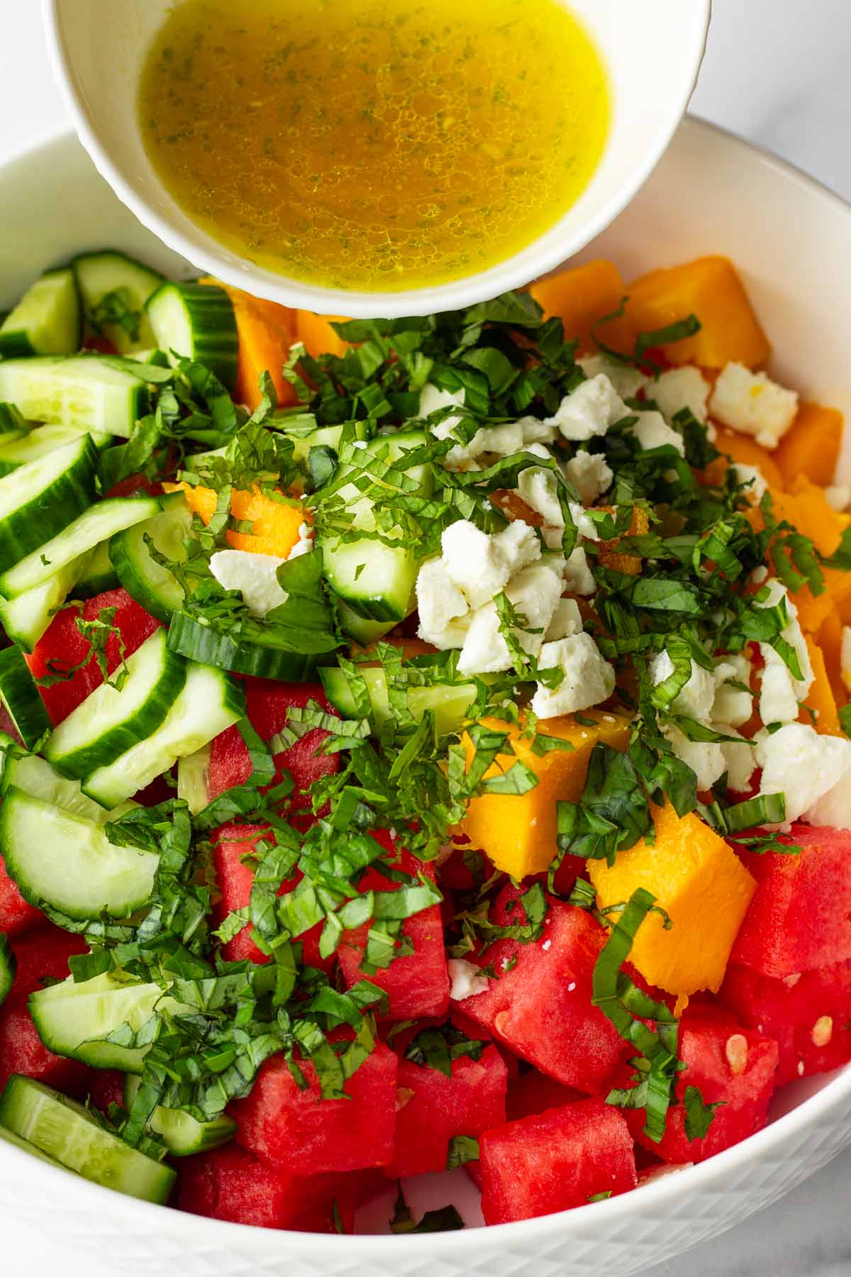 adding honey lime dressing to salad