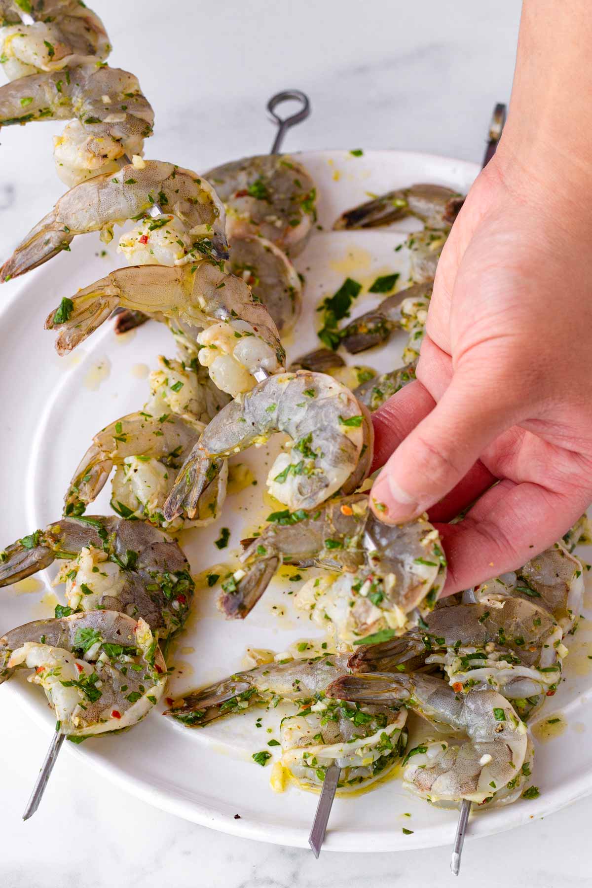 threading shrimp in metal skewers