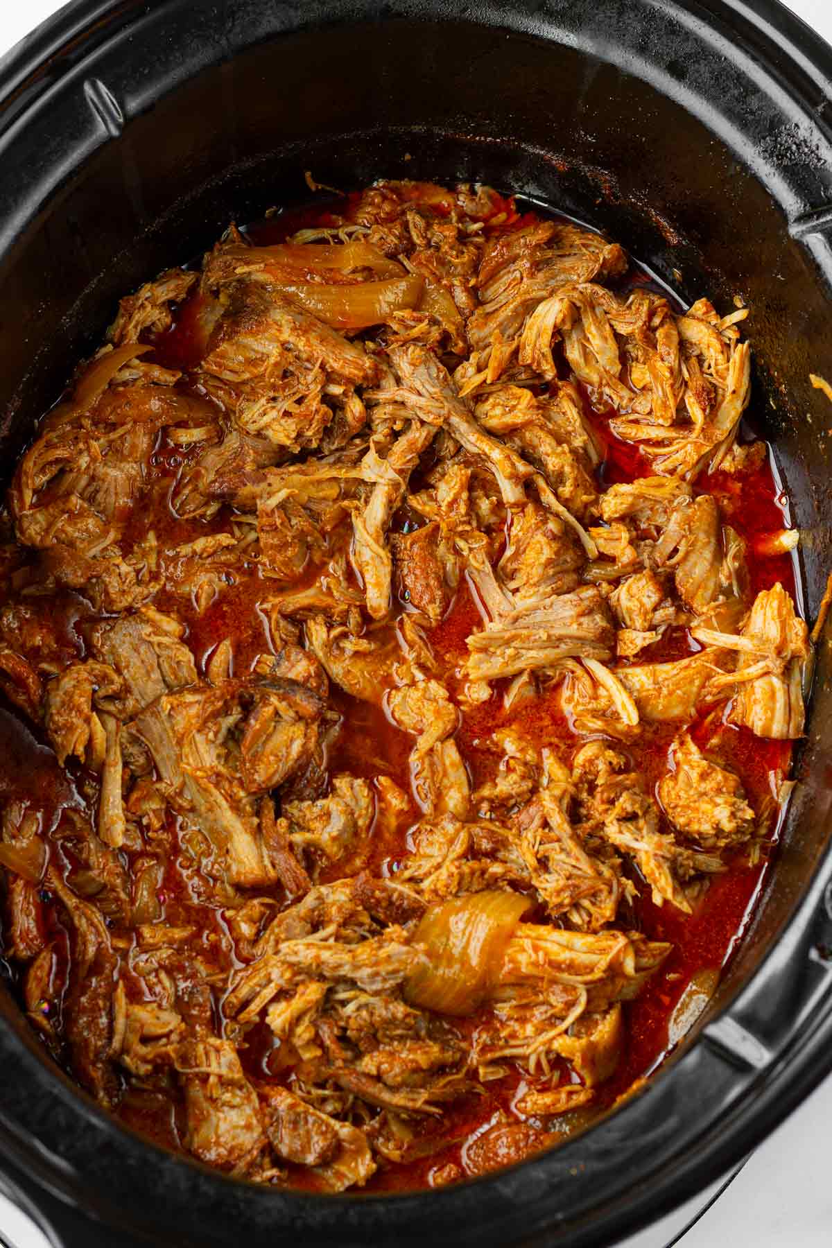 shredded pulled pork resting the juices in crockpot