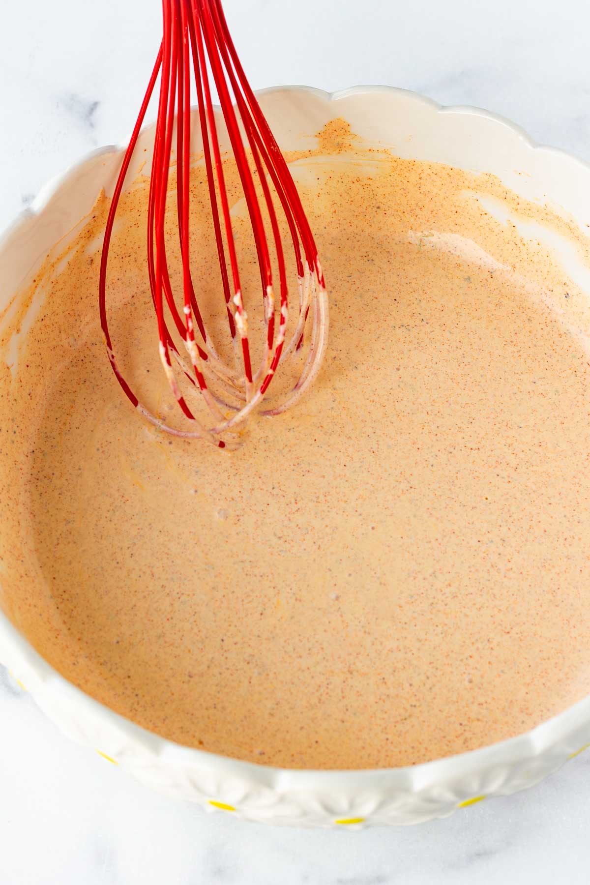whisking dressing for the salad in bowl