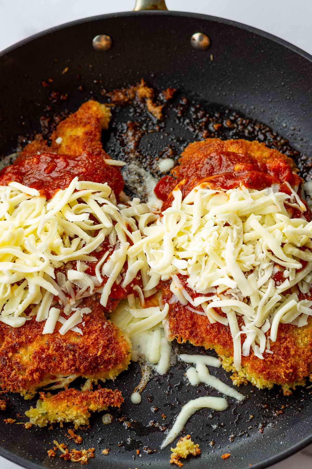 adding cheese on chicken parmesan