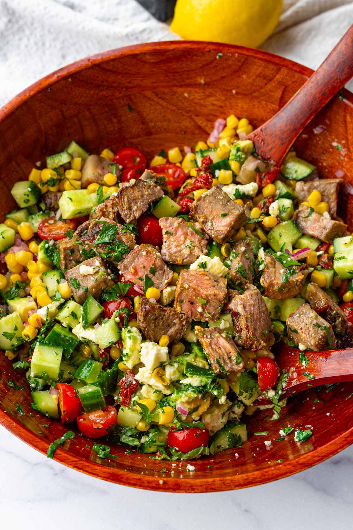 chopped steak salad with cucumbers, tomatoes, avocado, herbs, cheese