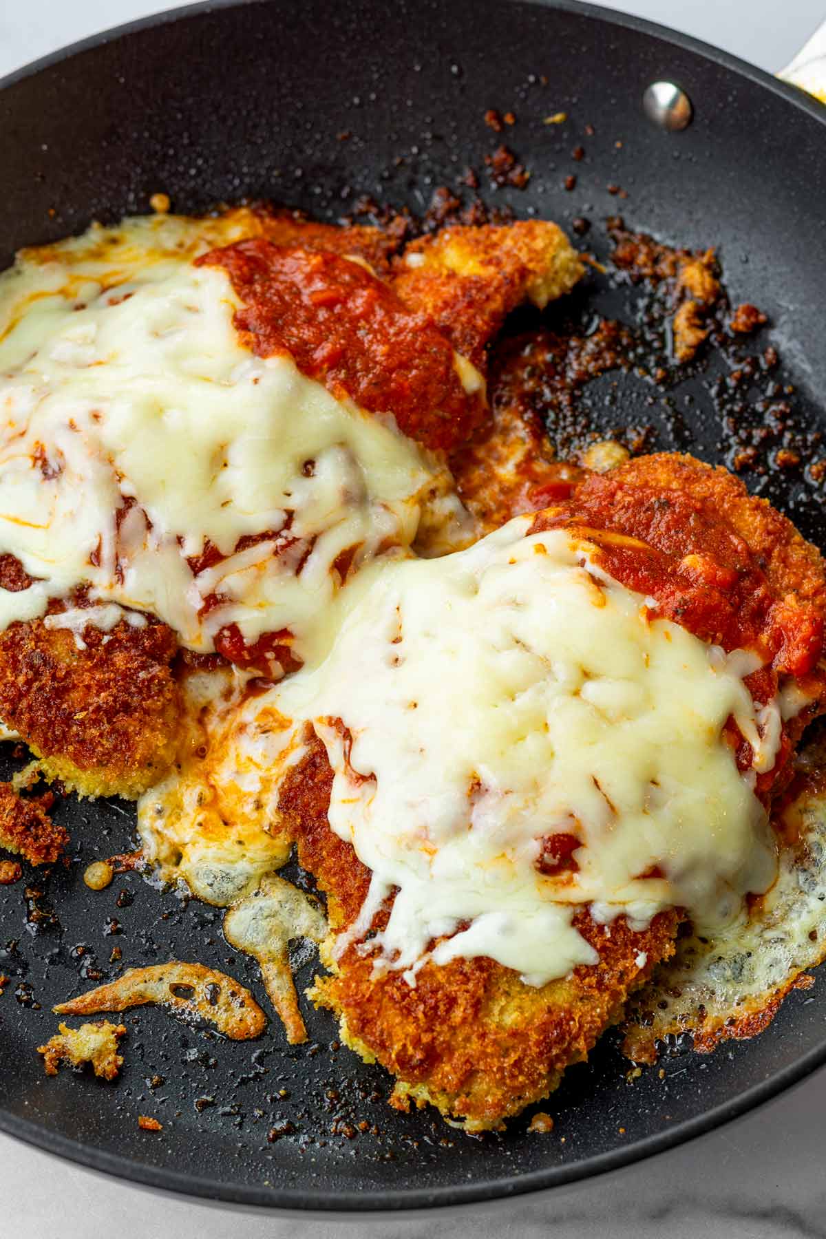 melty chicken parmesan dish on skillet