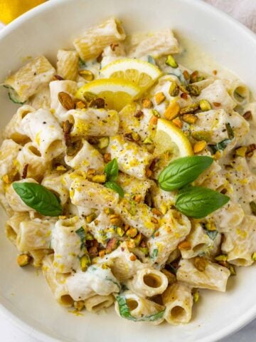 garnished lemon ricotta pasta with basil, pistachios, lemons