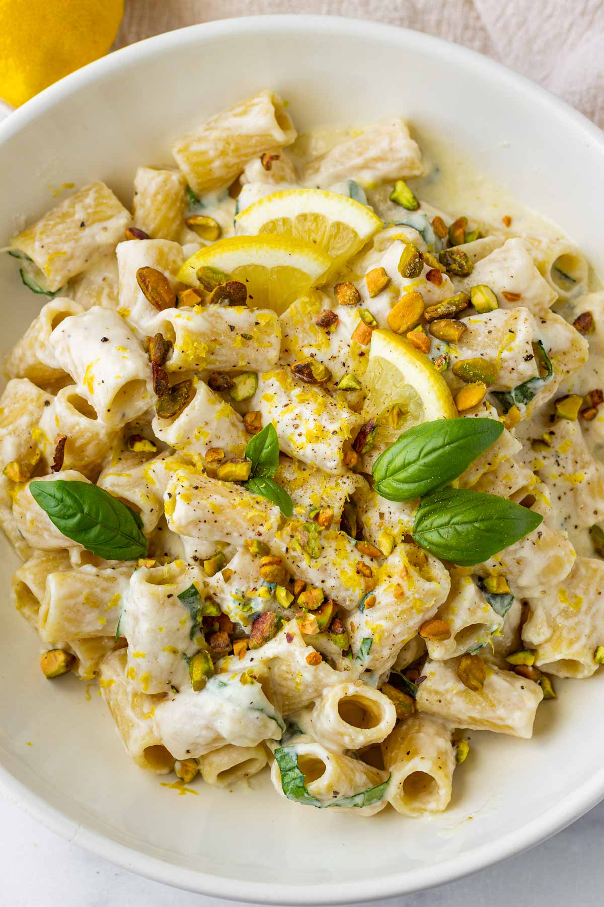 garnished lemon ricotta pasta with basil, pistachios, lemons