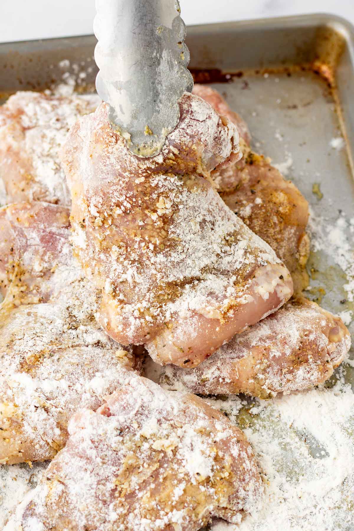 seasoning and dredging chicken with light layer of flour