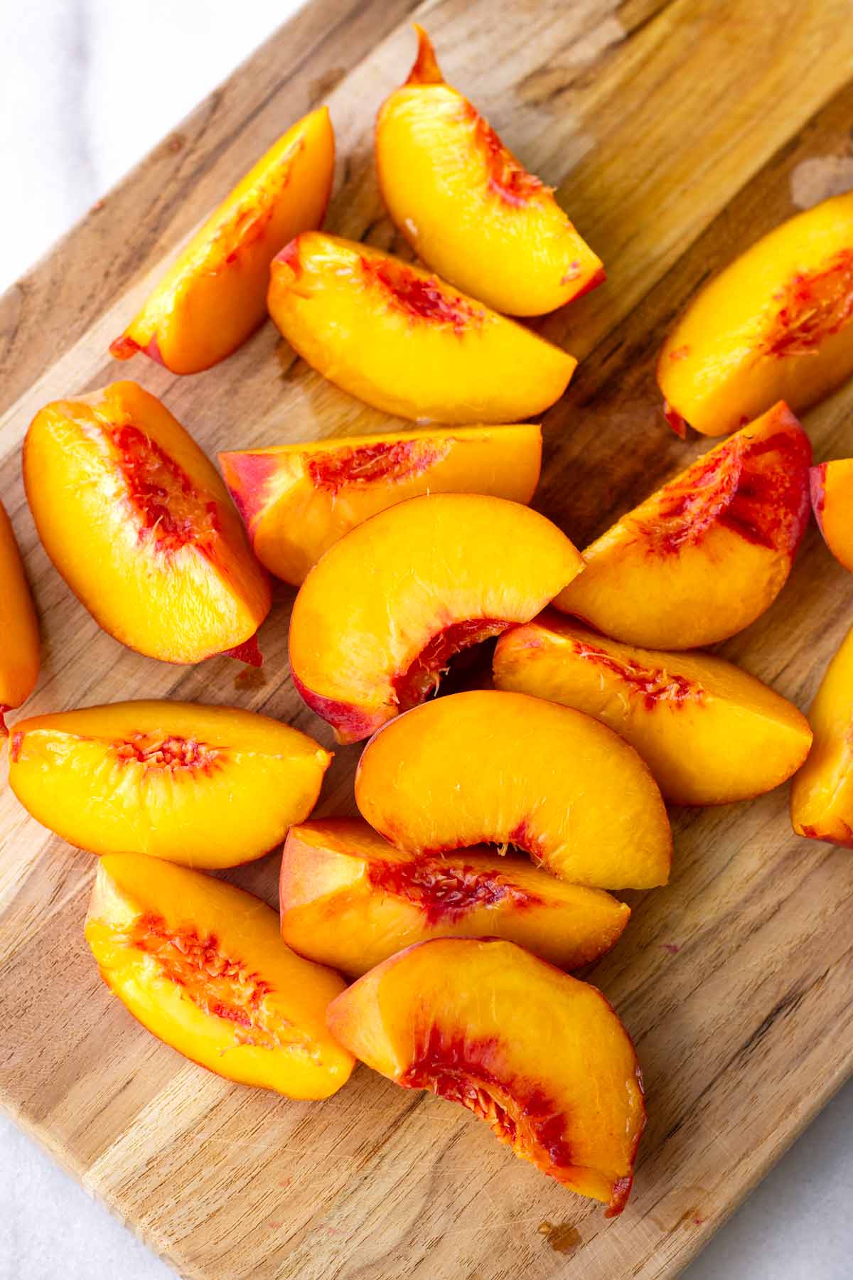 sliced peach wedges in cutting board