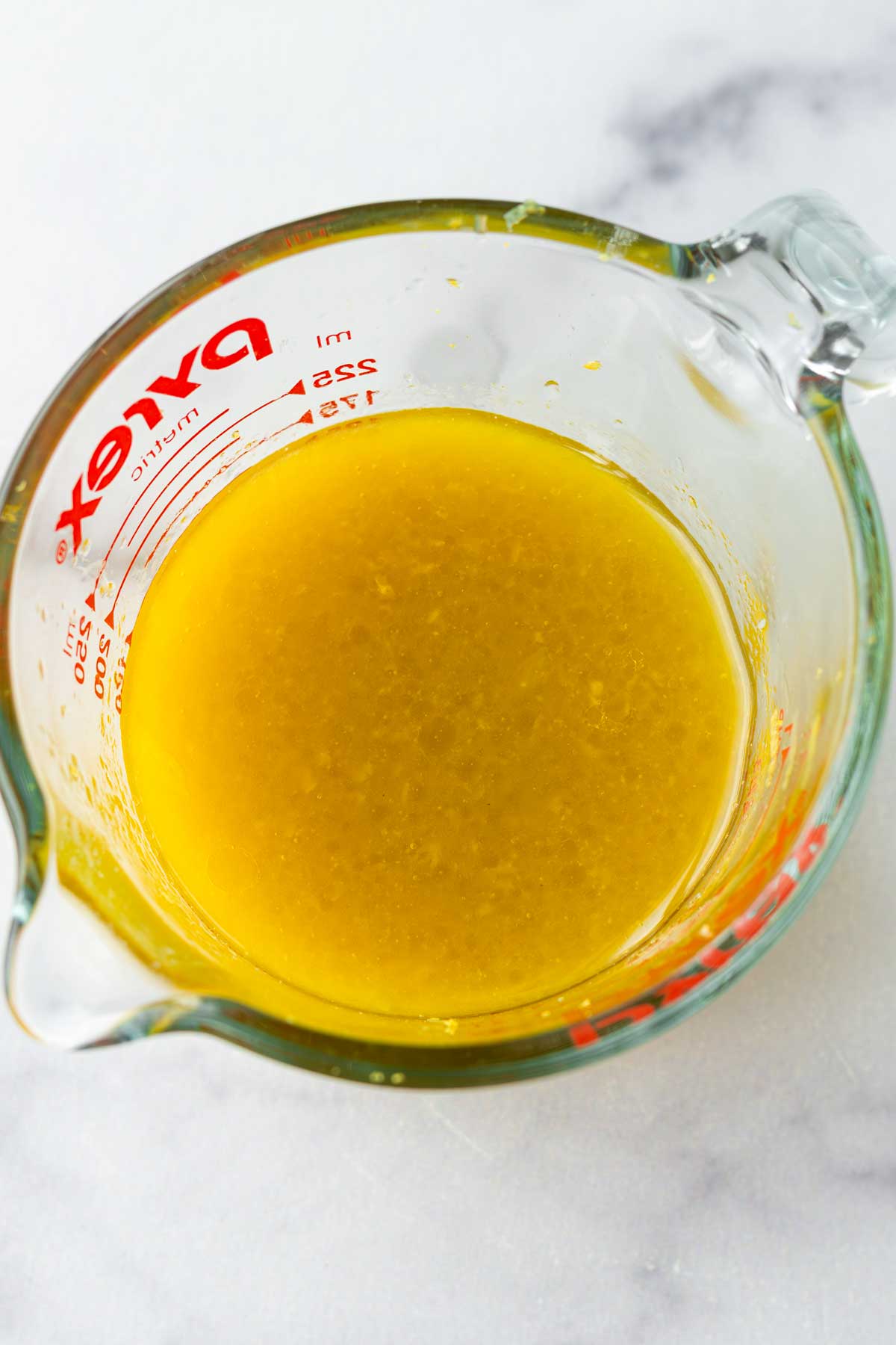 hot honey lemon dressing in measuring cup