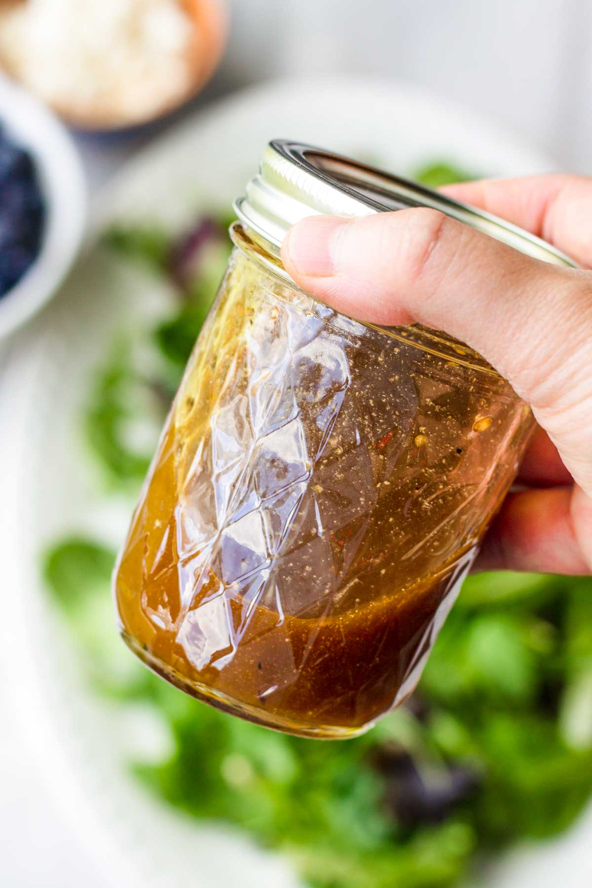 shaking balsamic dressing in a mason jar