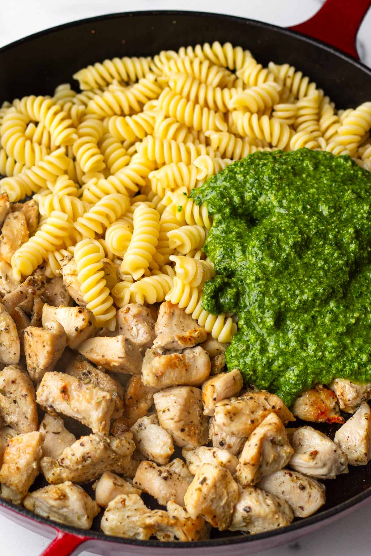 pasta, chicken, and basil pesto in the skillet before combining