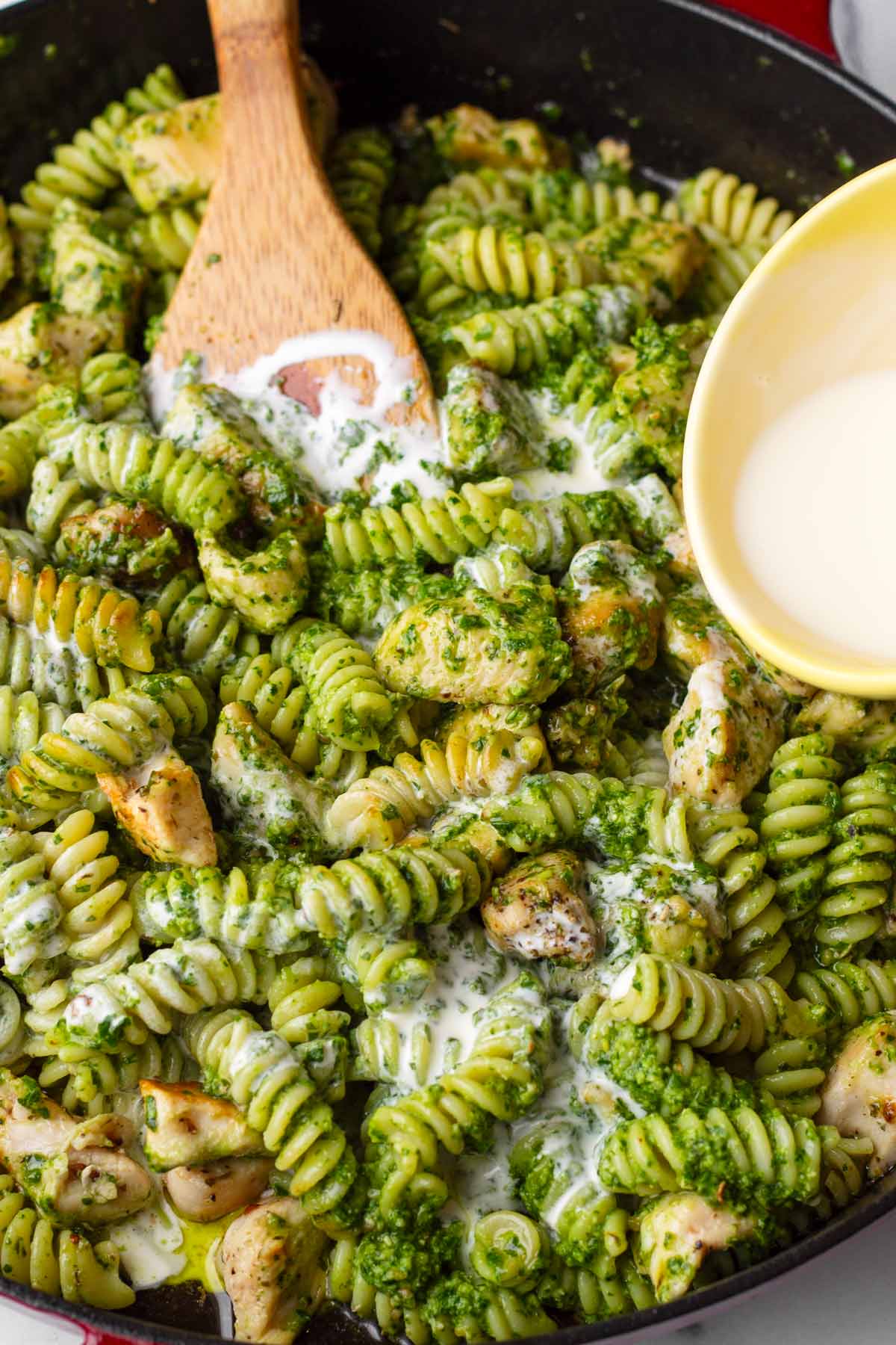 adding cream to the chicken pesto pasta