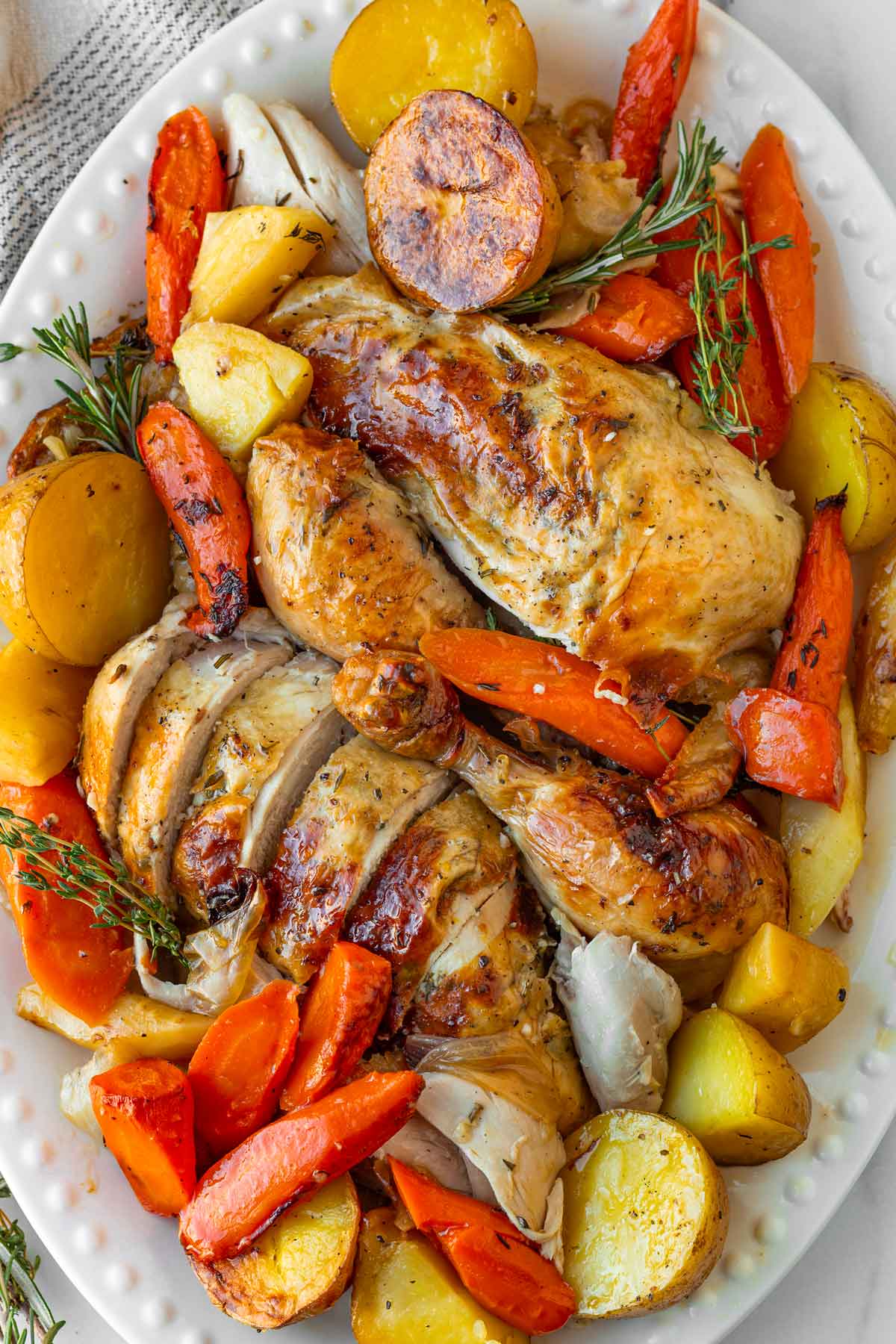 sliced up and carved chicken on a platter with vegetables
