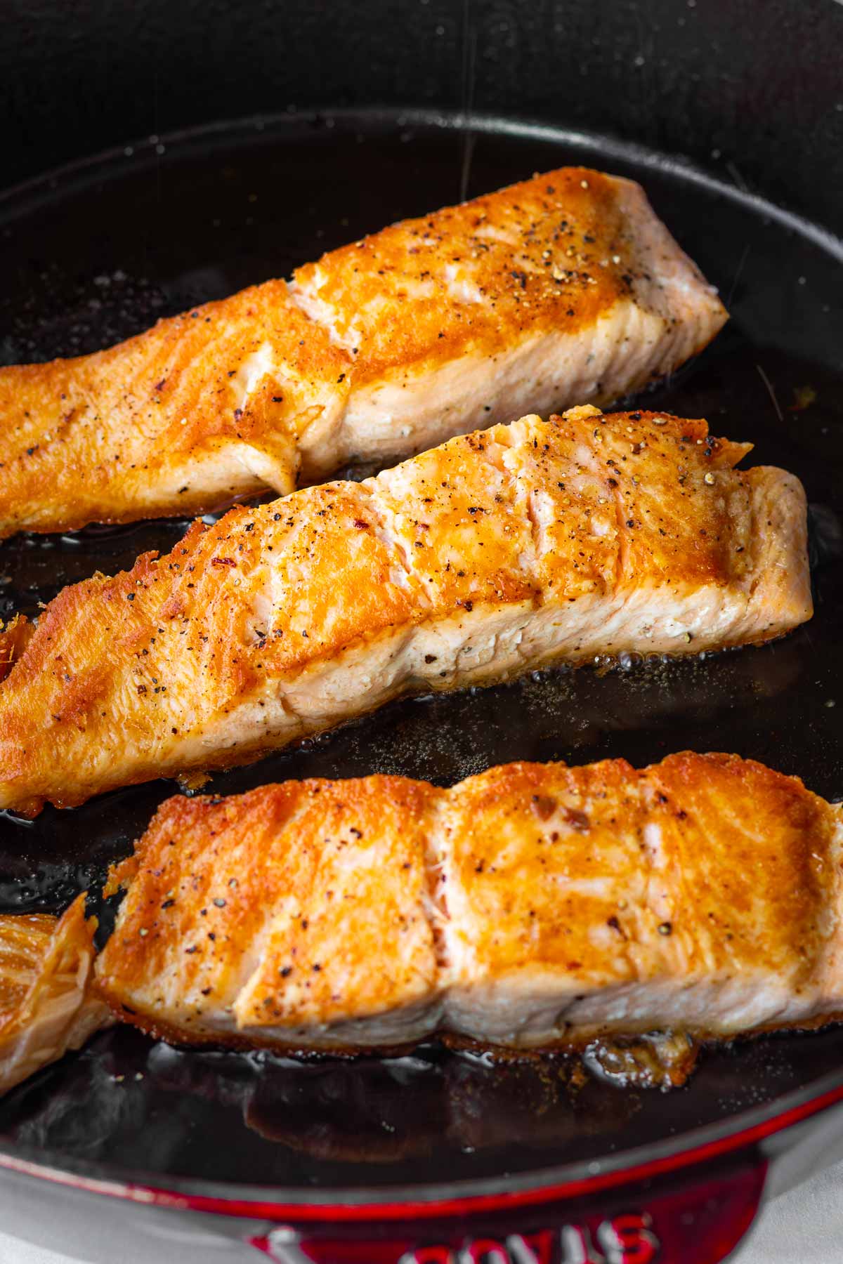 seared salmon filets in cast iron pan