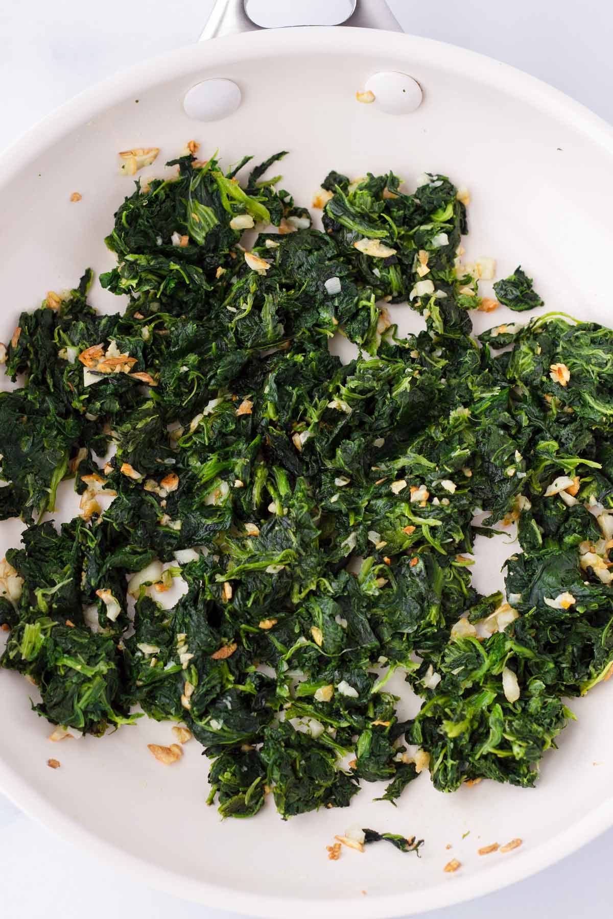suated spinach with garlic in pan