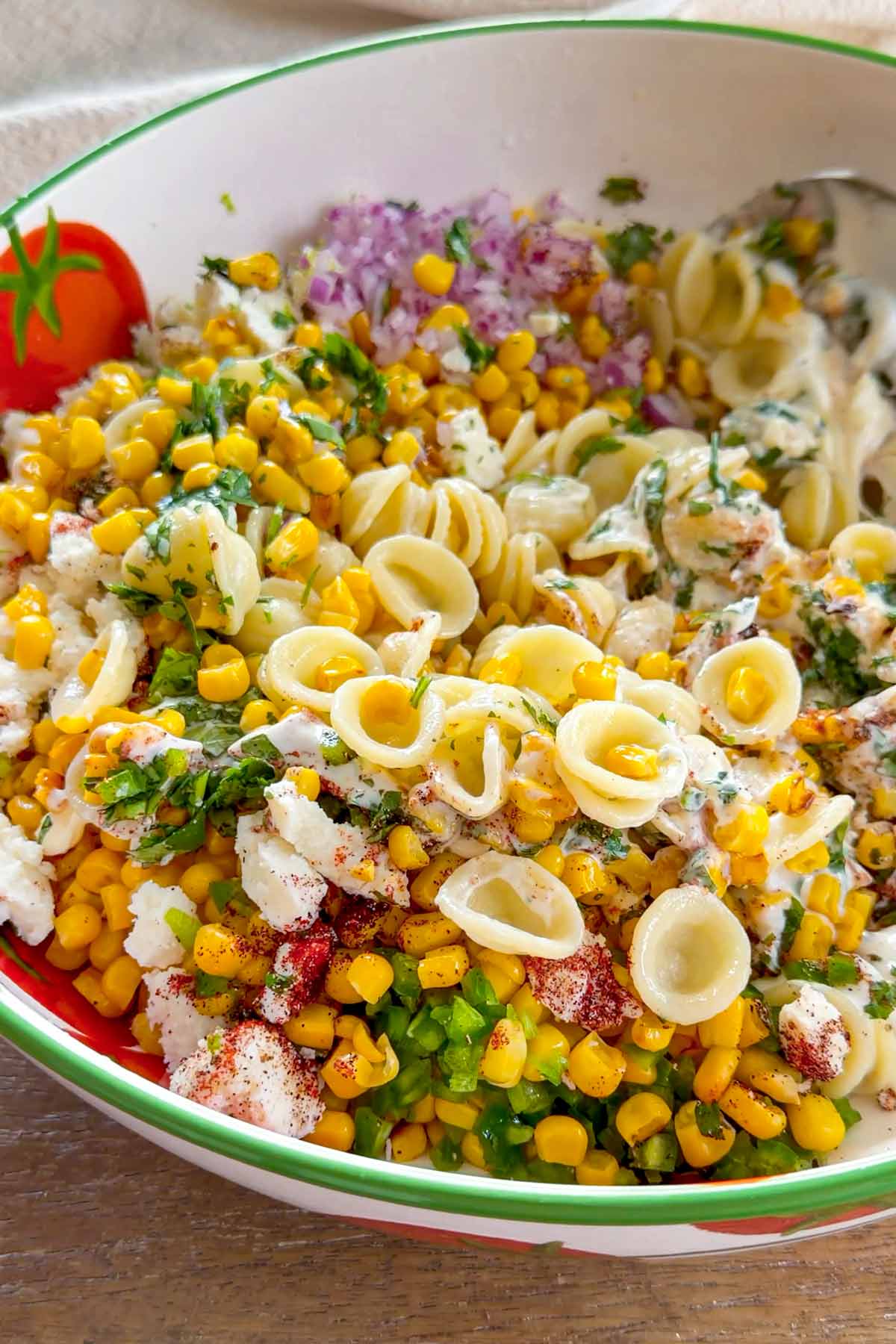 tossing to combine the mexican street corn pasta salad