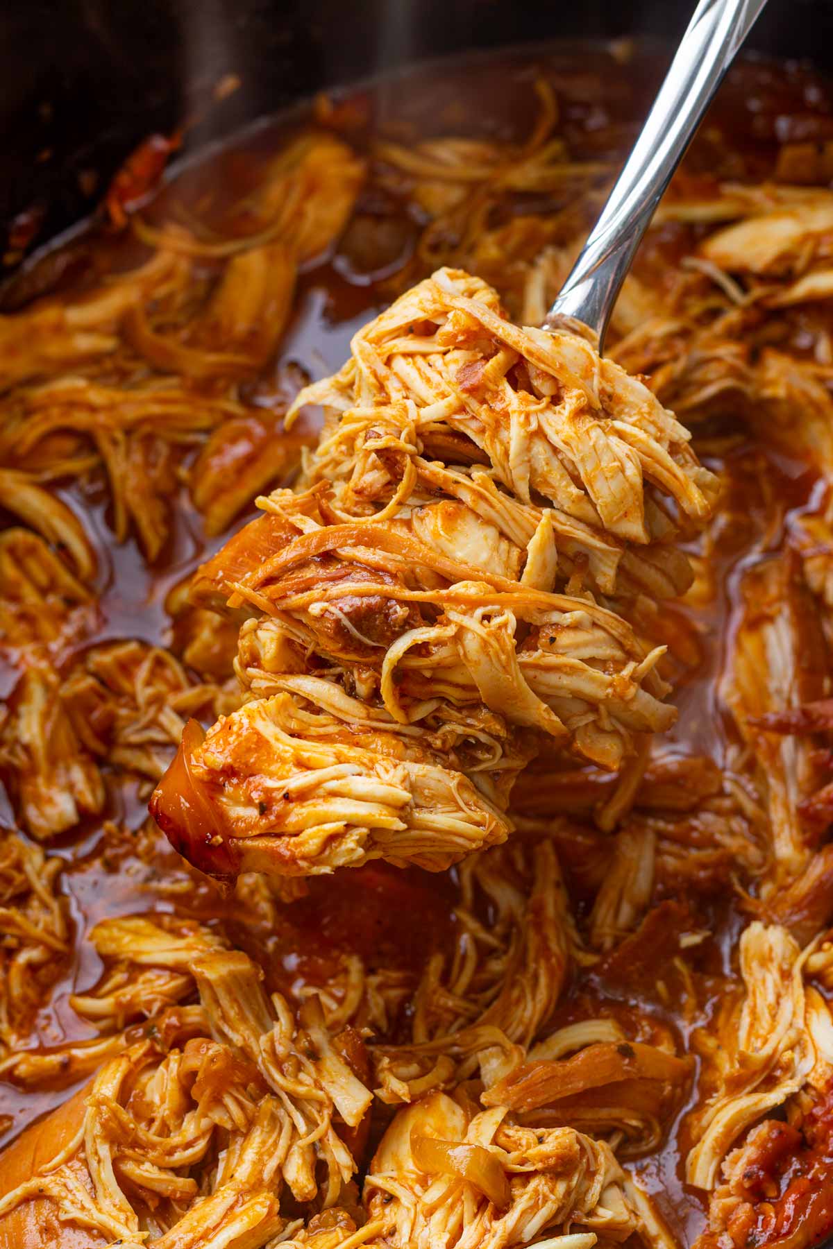 a spoonful of pulled chicken cooked in crockpot