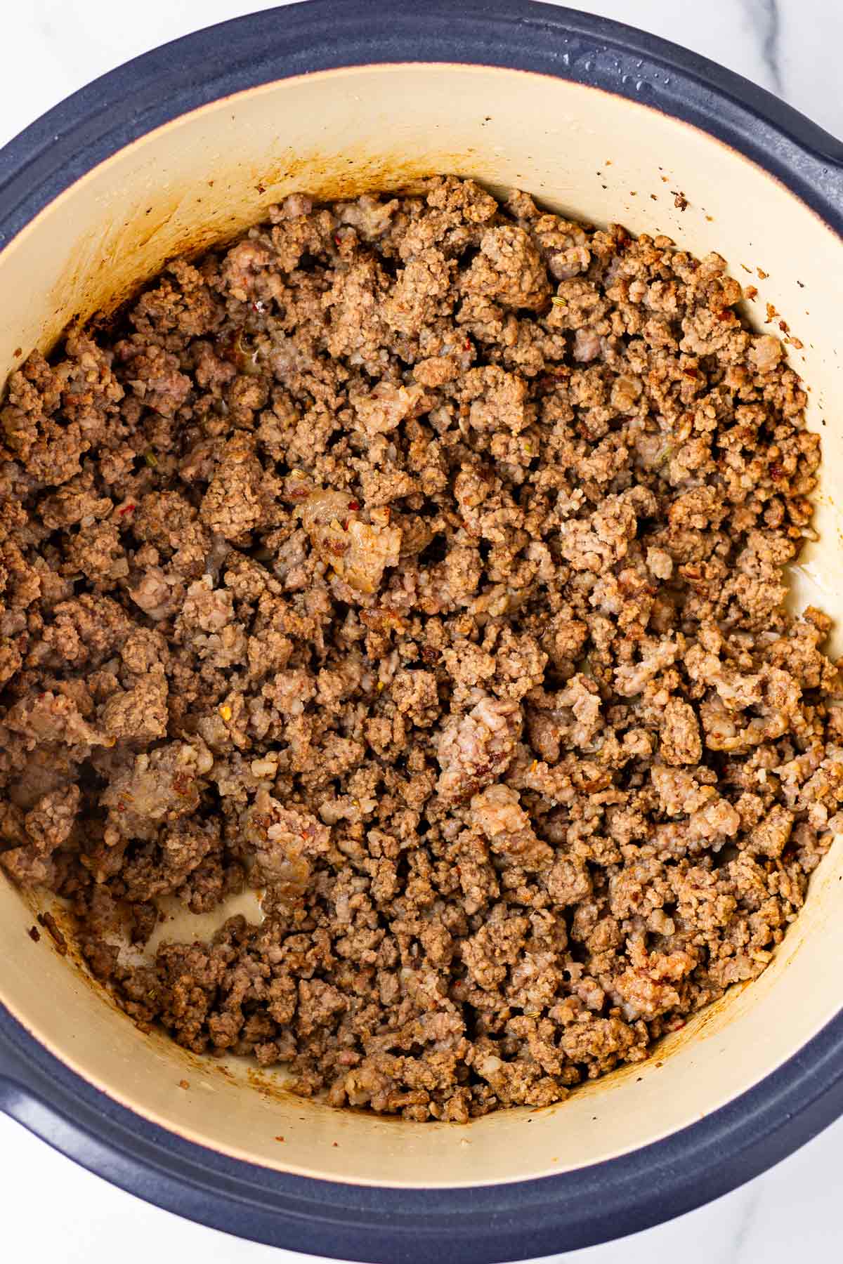 browned beef and italian sausage in simmering pot