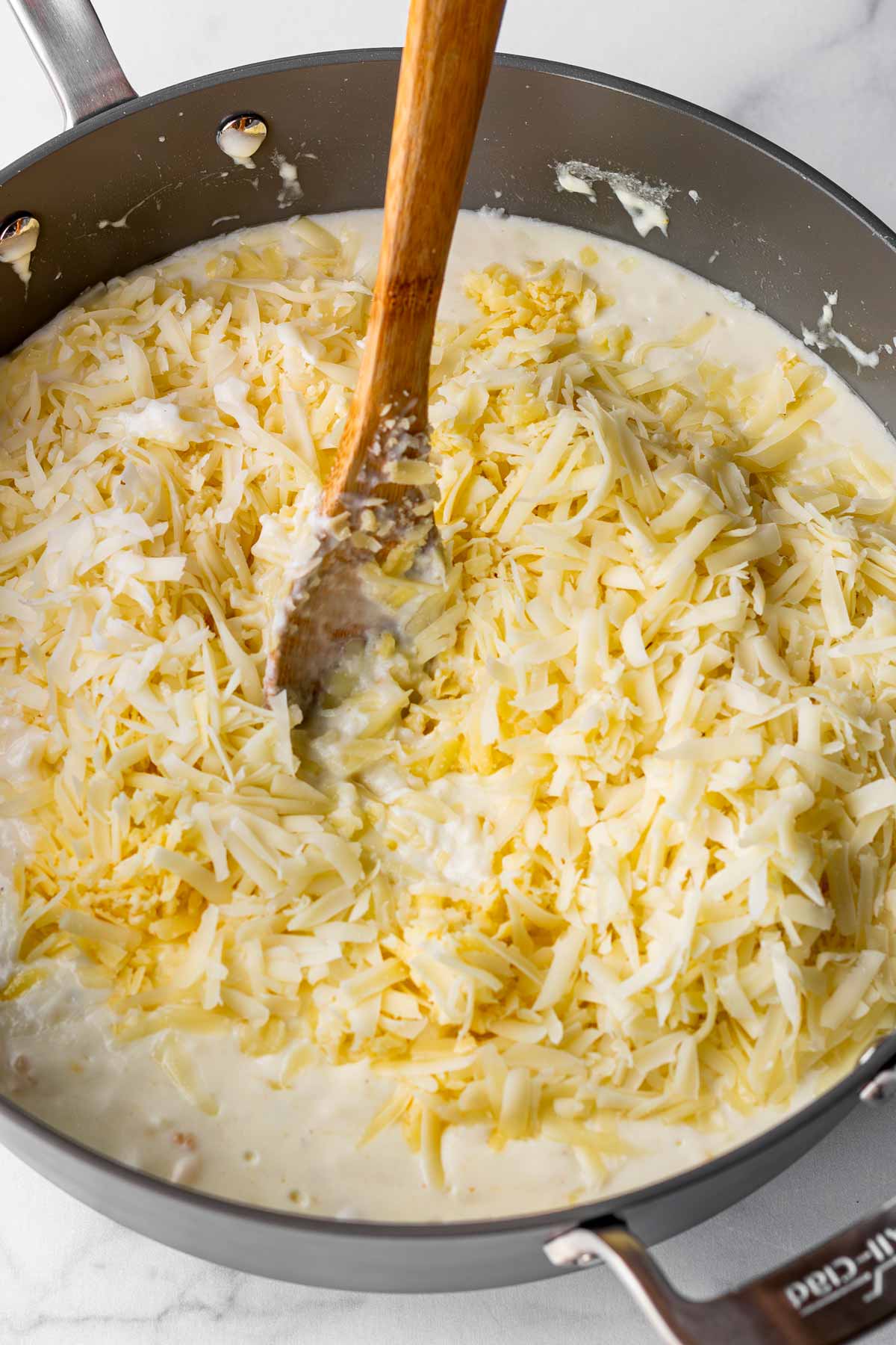 adding cheese into the creamy sauce