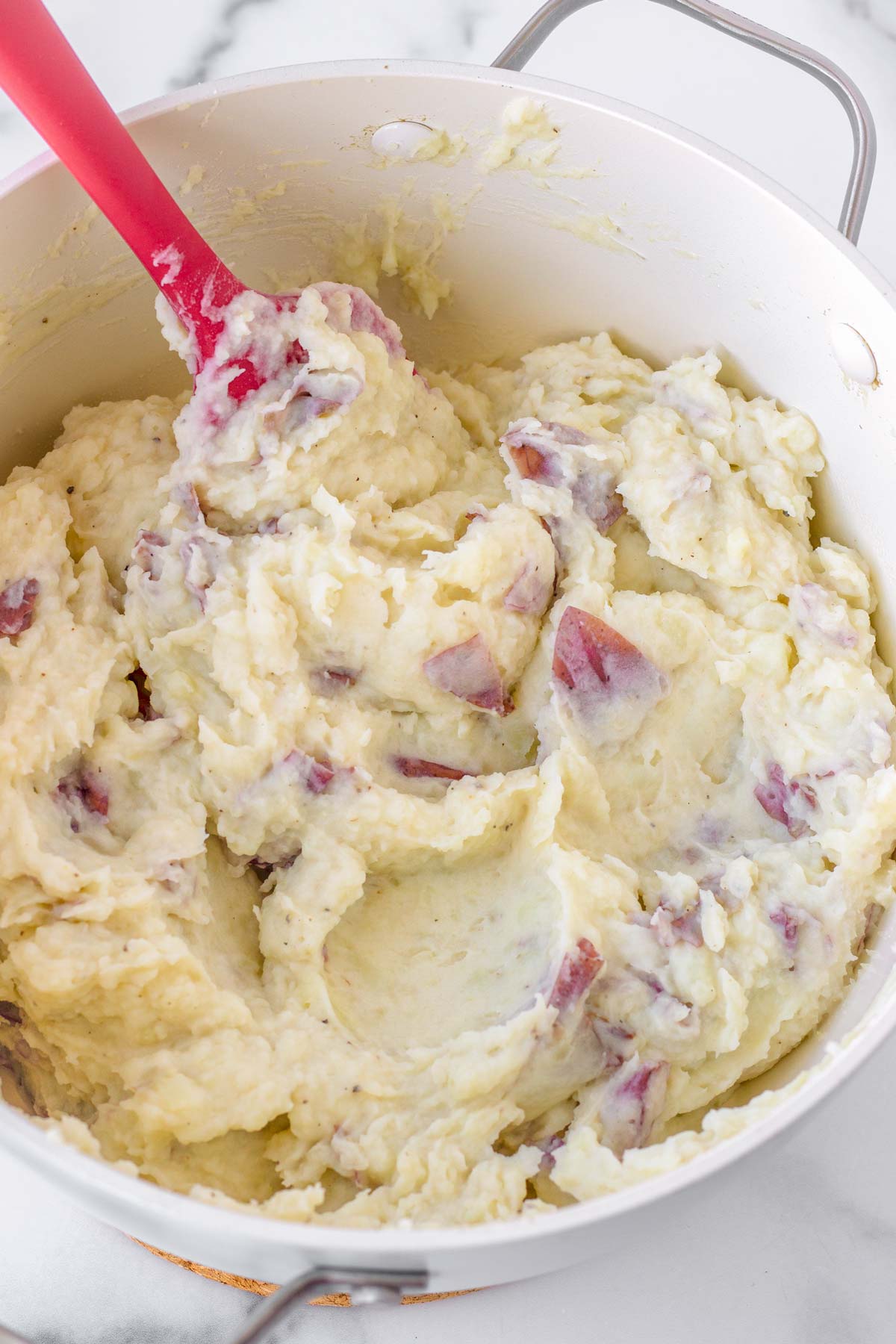 mashing and mixing the red mashed potatoes