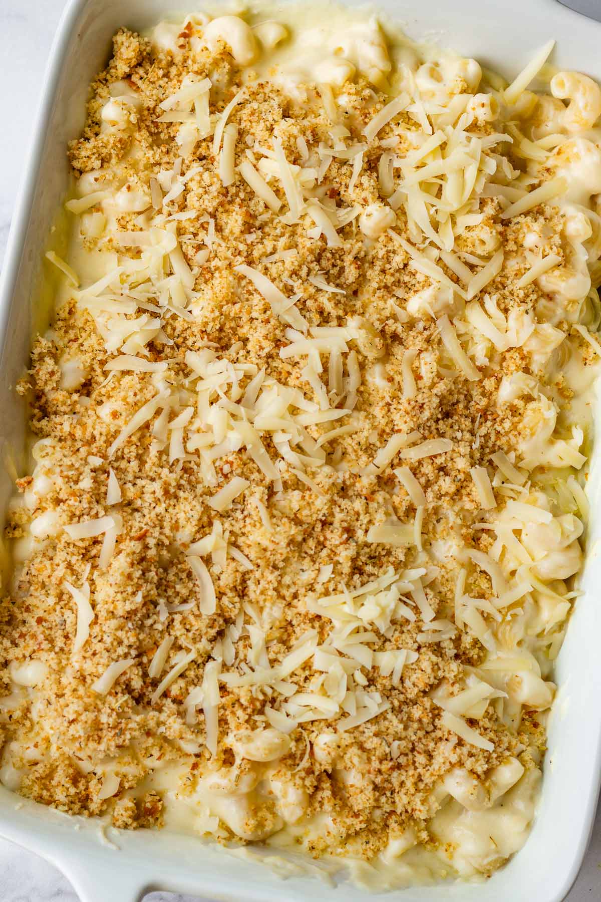 prepared mac and cheese on baking pan with topping for baking