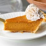 a slice of pumpkin pie with sweetened condensed milk served with spice