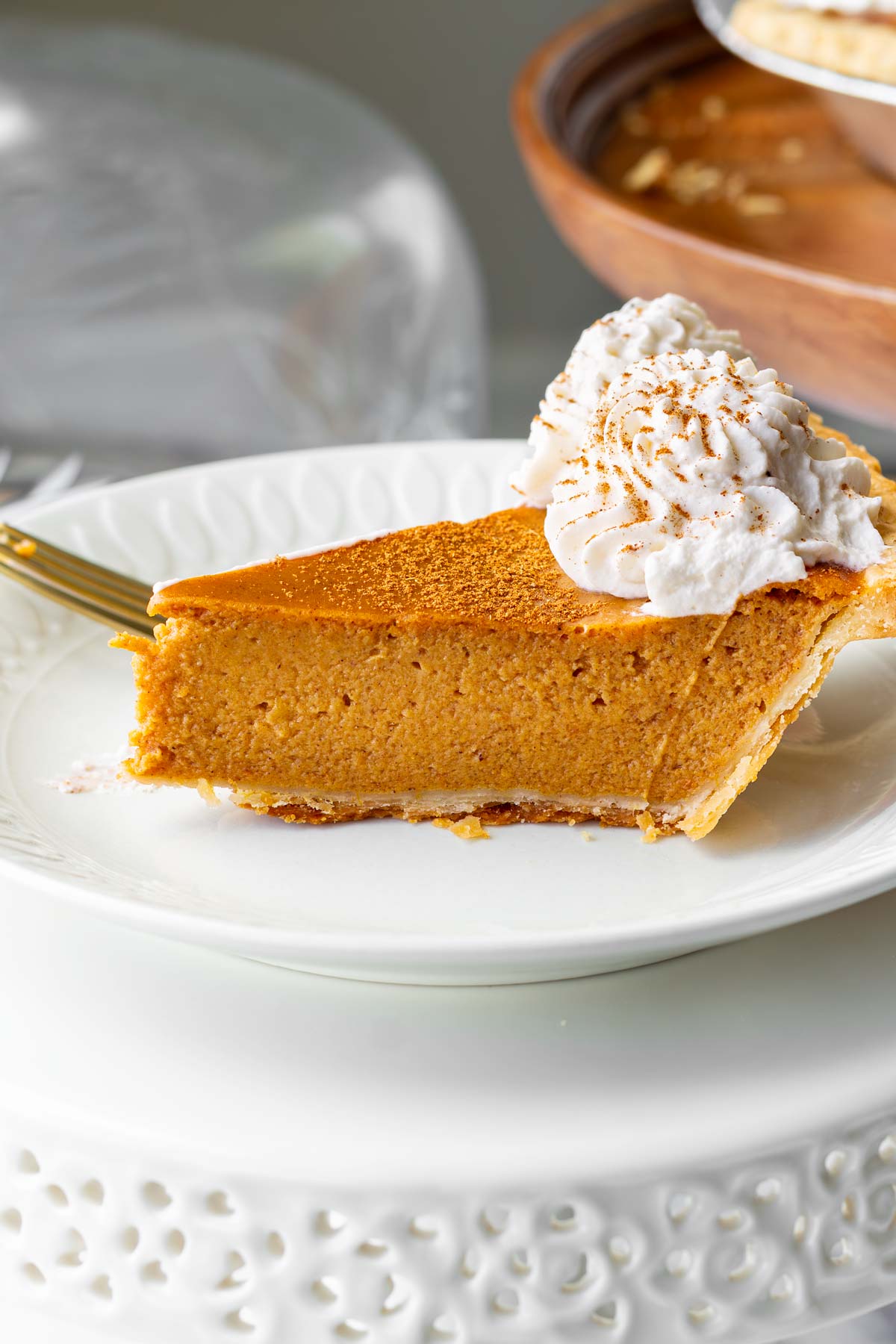 a slice of pumpkin pie with sweetened condensed milk served with spice and whipped cream