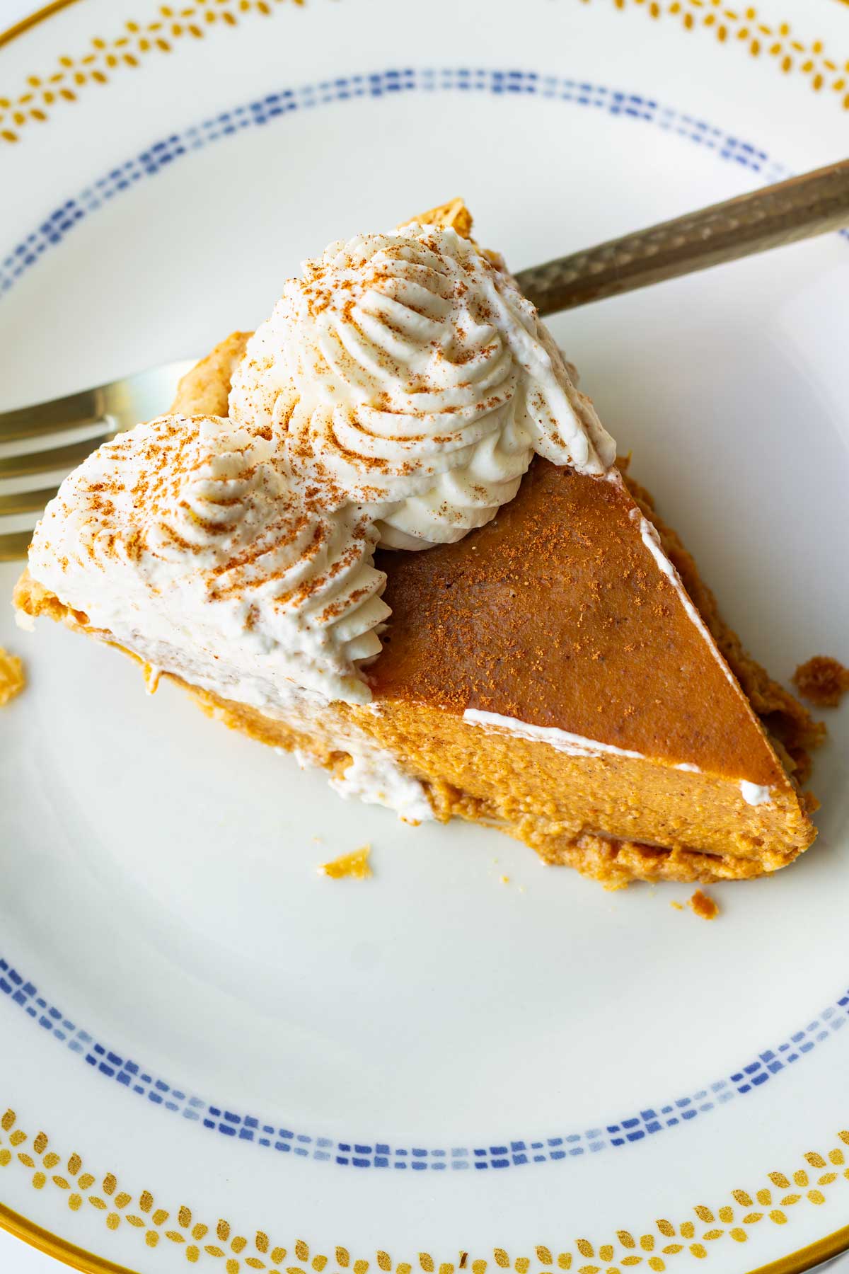 a slice of pumpkin with with whipped cream on a plate