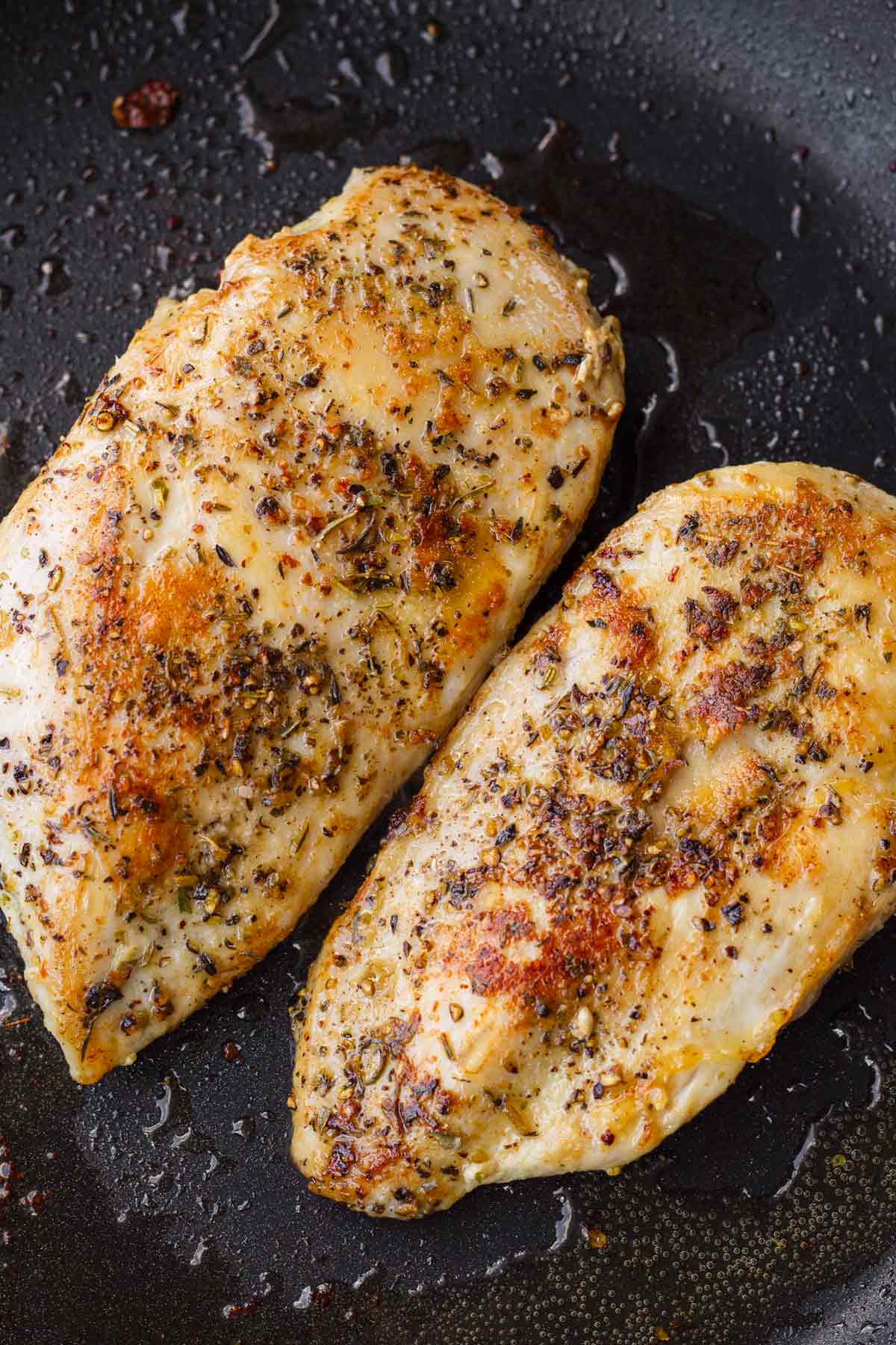 searing the seasoned chicken in a pan