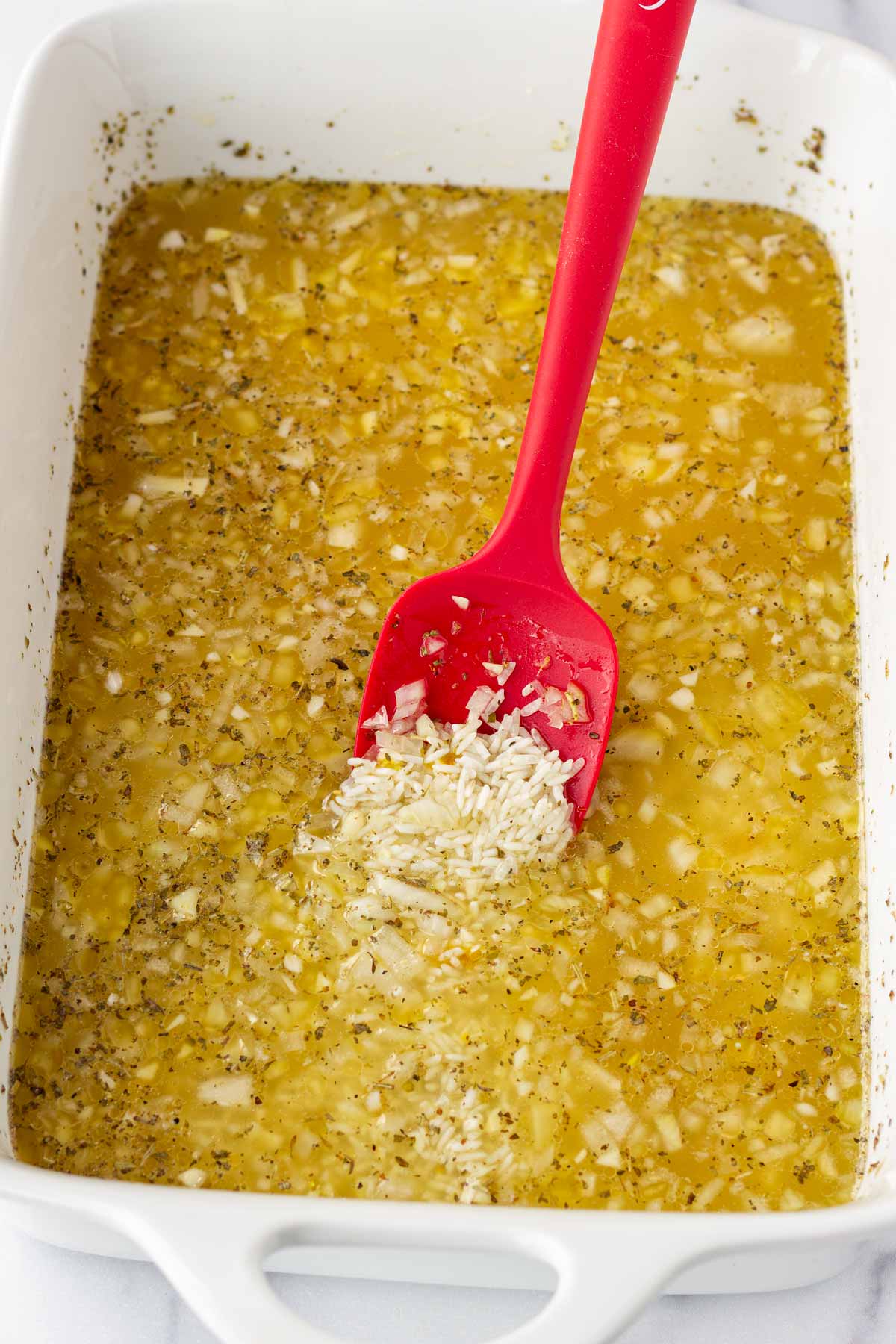 combining rice with broth and aromatics