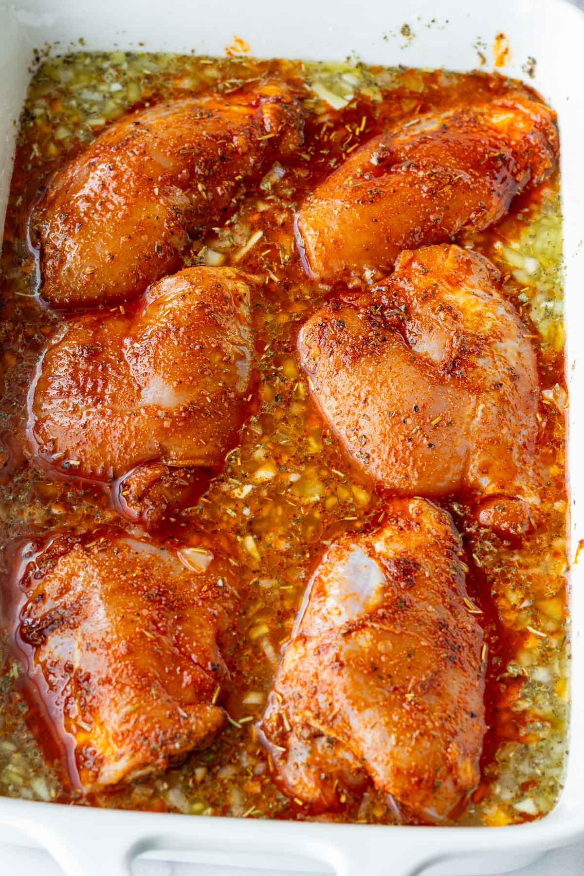 adding seasoned chicken on top of the rice and liquid