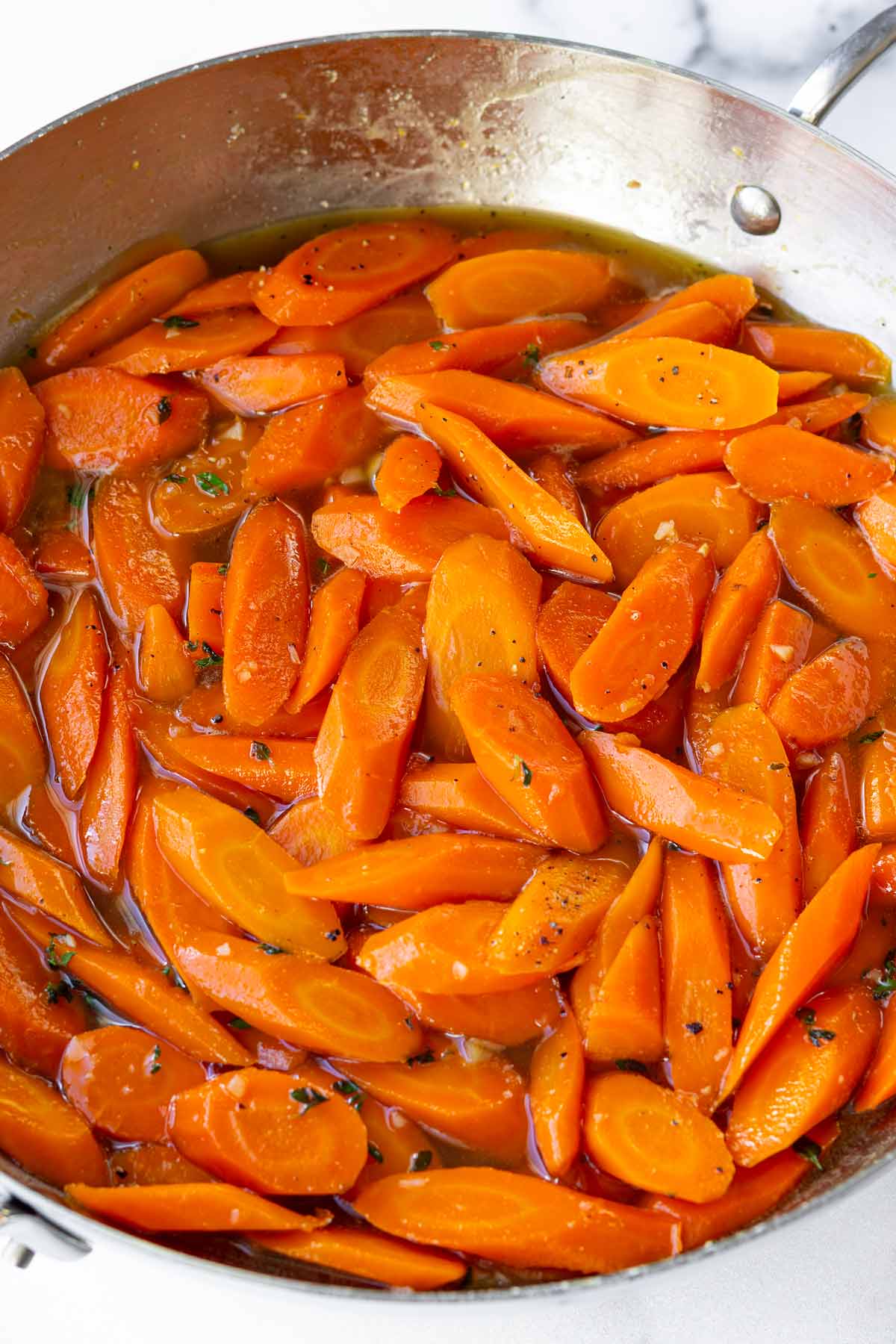 carrots simmering in the brown sugar glaze in pan
