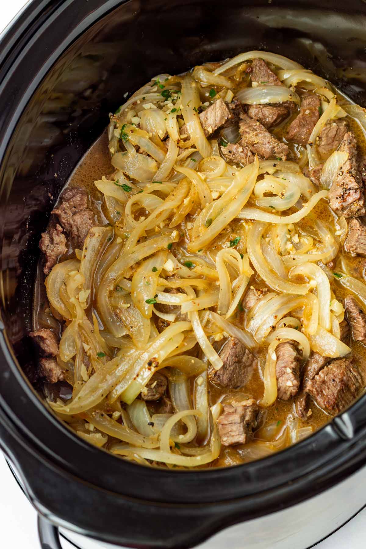 added onions, seared beef, and liquid into crockpot prior to cooking
