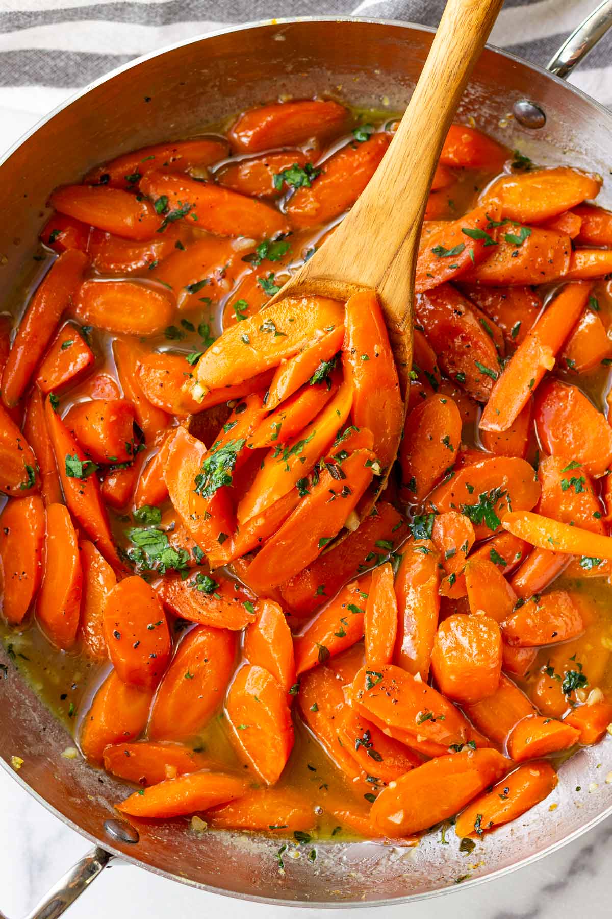 brown sugar carrots in a skillet with serving spoon