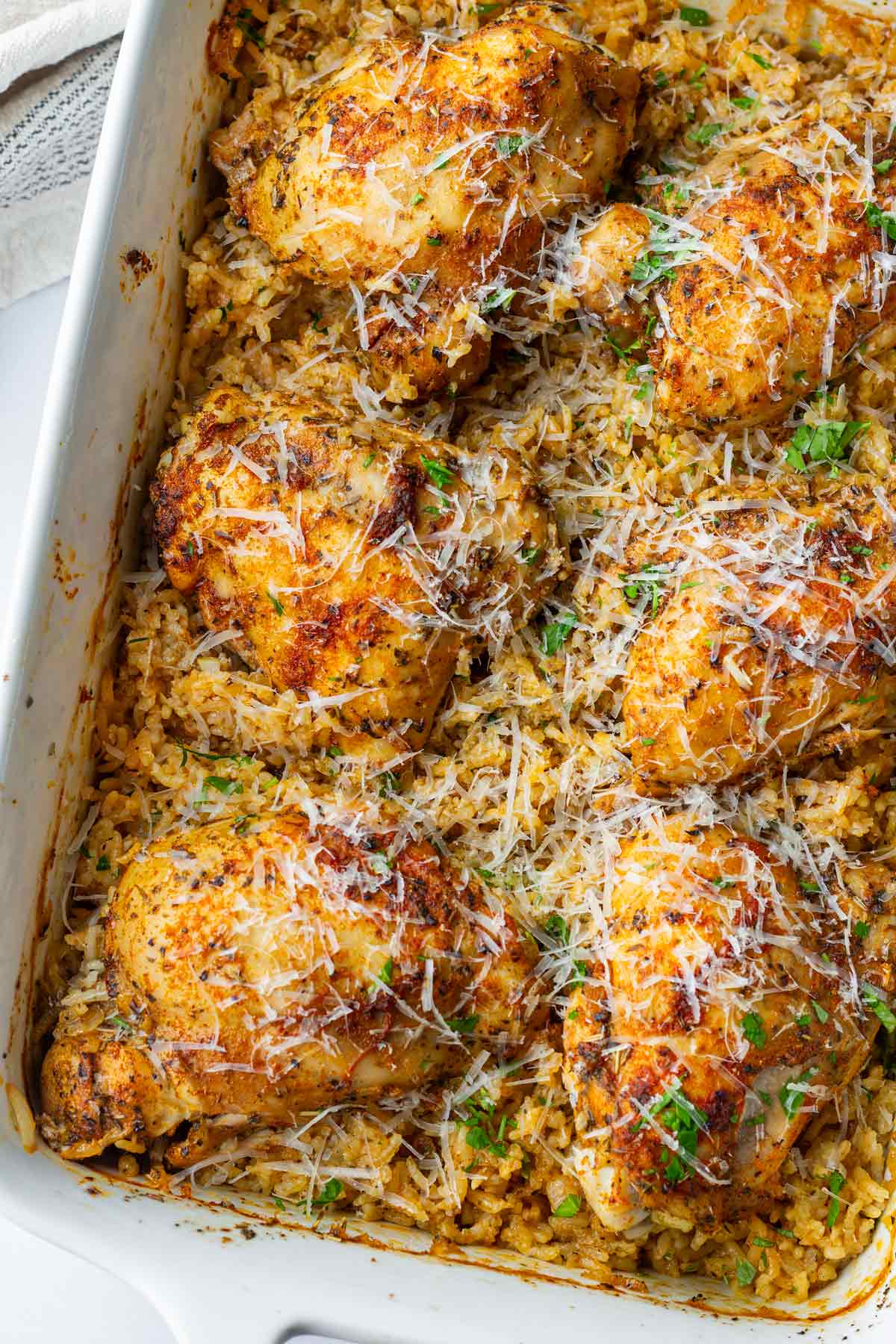 garnished baked chicken and rice with cheese on top
